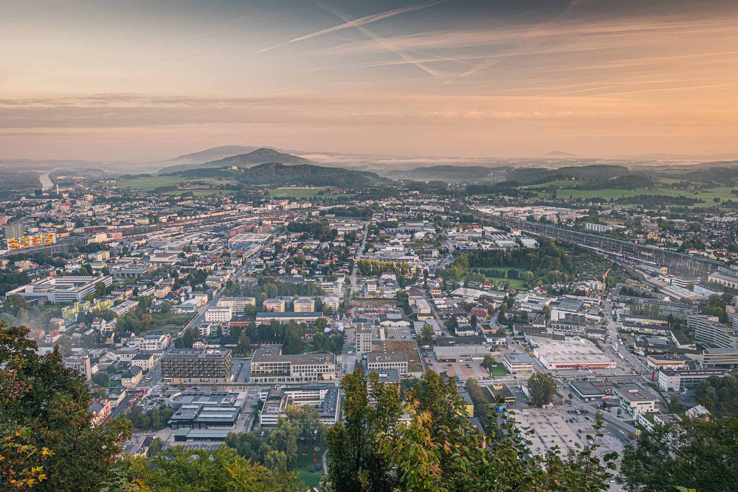 Panoramic view east over Salzburg suburbs and hills at dawn from Kapuzinerberg in Salzburg.