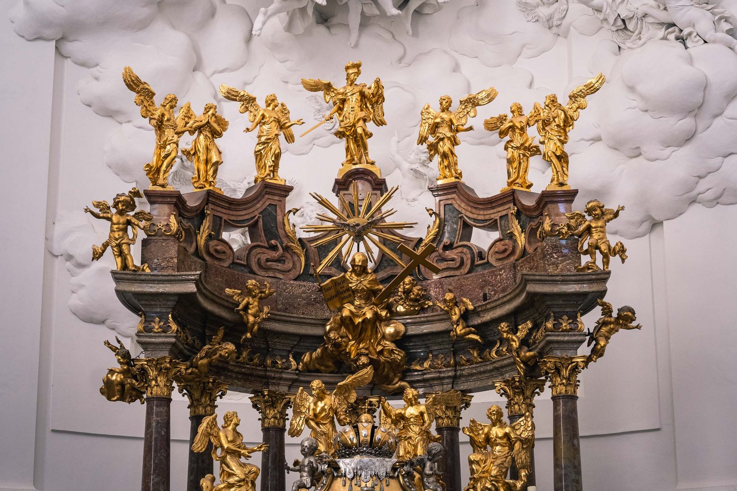 Baroque high altar with gilded angels and stucco clouds inside Kollegienkirche in Salzburg old town