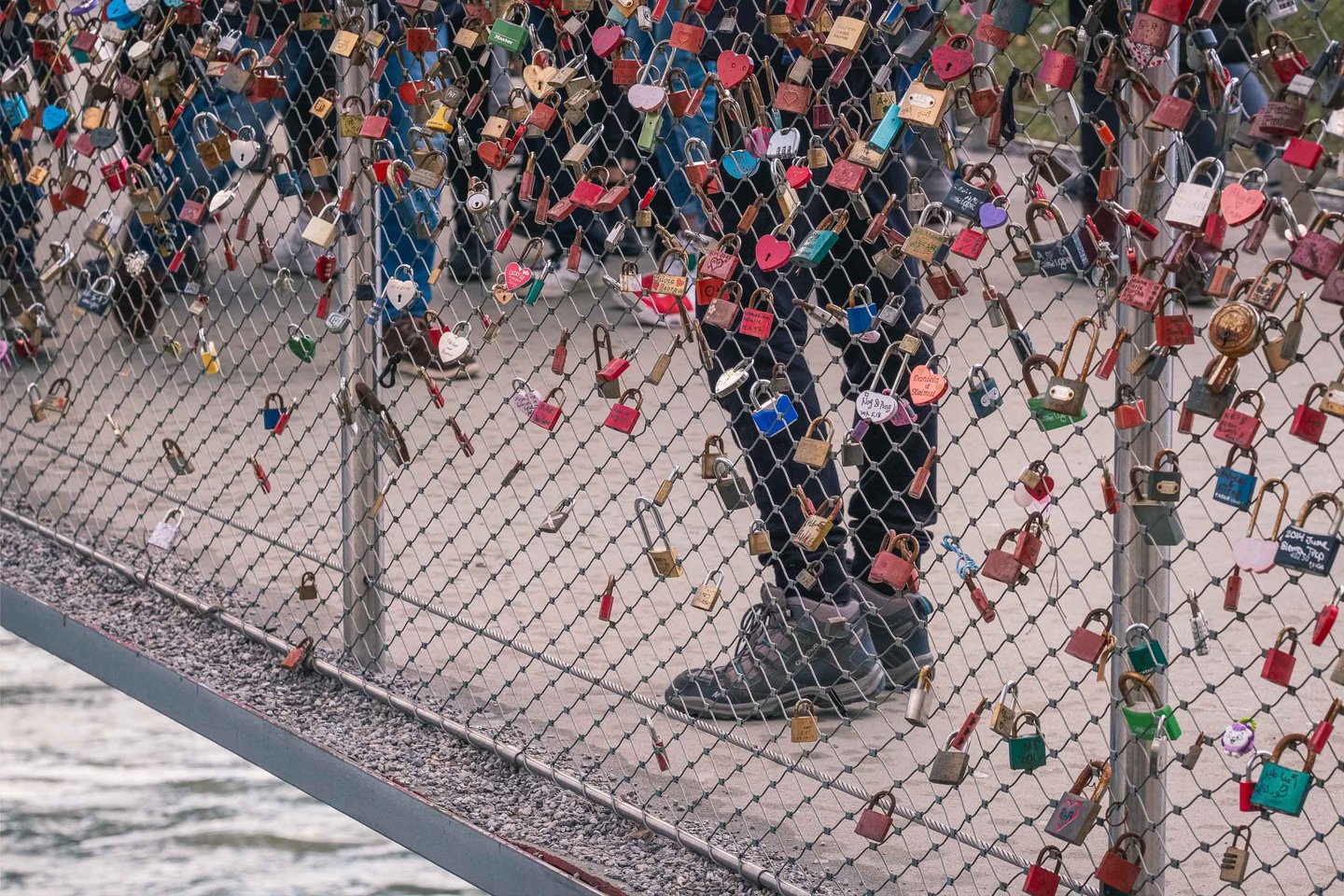 Dense love locks attached to the mesh railing of Makartsteg pedestrian bridge in Salzburg.