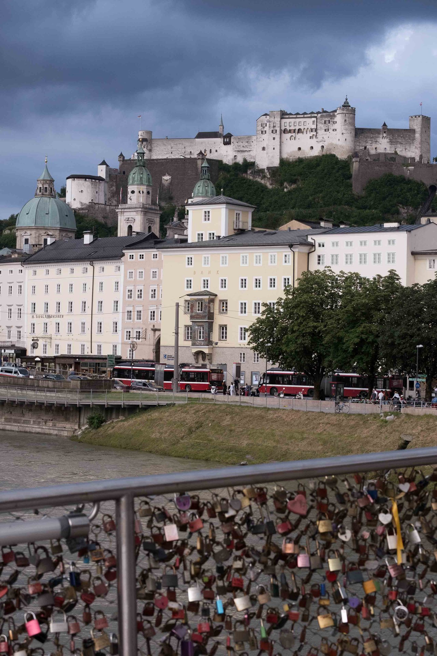 Love locks on Makartsteg bridge rail with Hohensalzburg Fortress rising above the Altstadt.