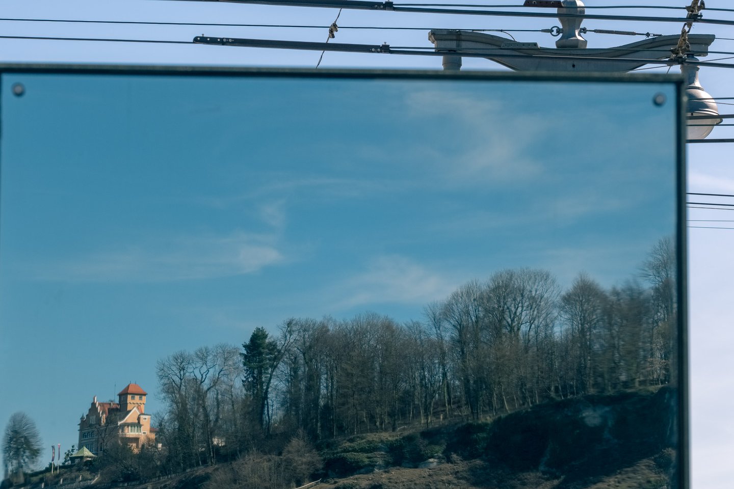 Reflection in a polished panel shows Schloss Edmundsburg perched atop the Moenchsberg cliff in Salzburg.