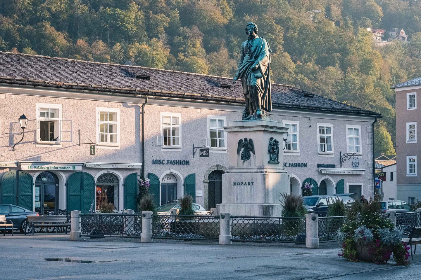 Mozart statue on Mozartplatz with old town buildings in Salzburg old town.