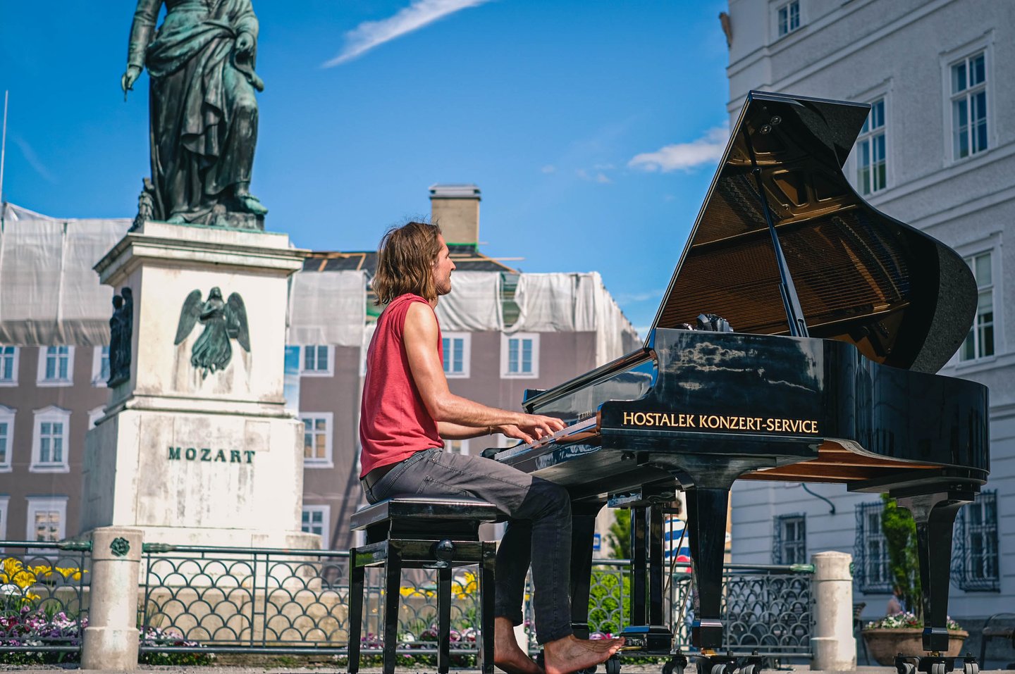 Barefoot pianist performs on a grand piano beside the Mozart monument on Mozartplatz in Salzburg