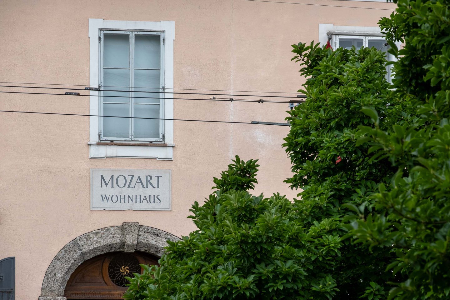 Painted Mozart Wohnhaus sign above the entry portal to Mozarts Residence in Salzburg.