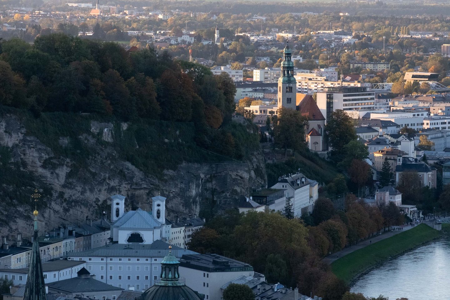 Mulln Church tower rises above Neustadt rooftops with the Salzach river seen from Hohensalzburg Fortress in Salzburg.