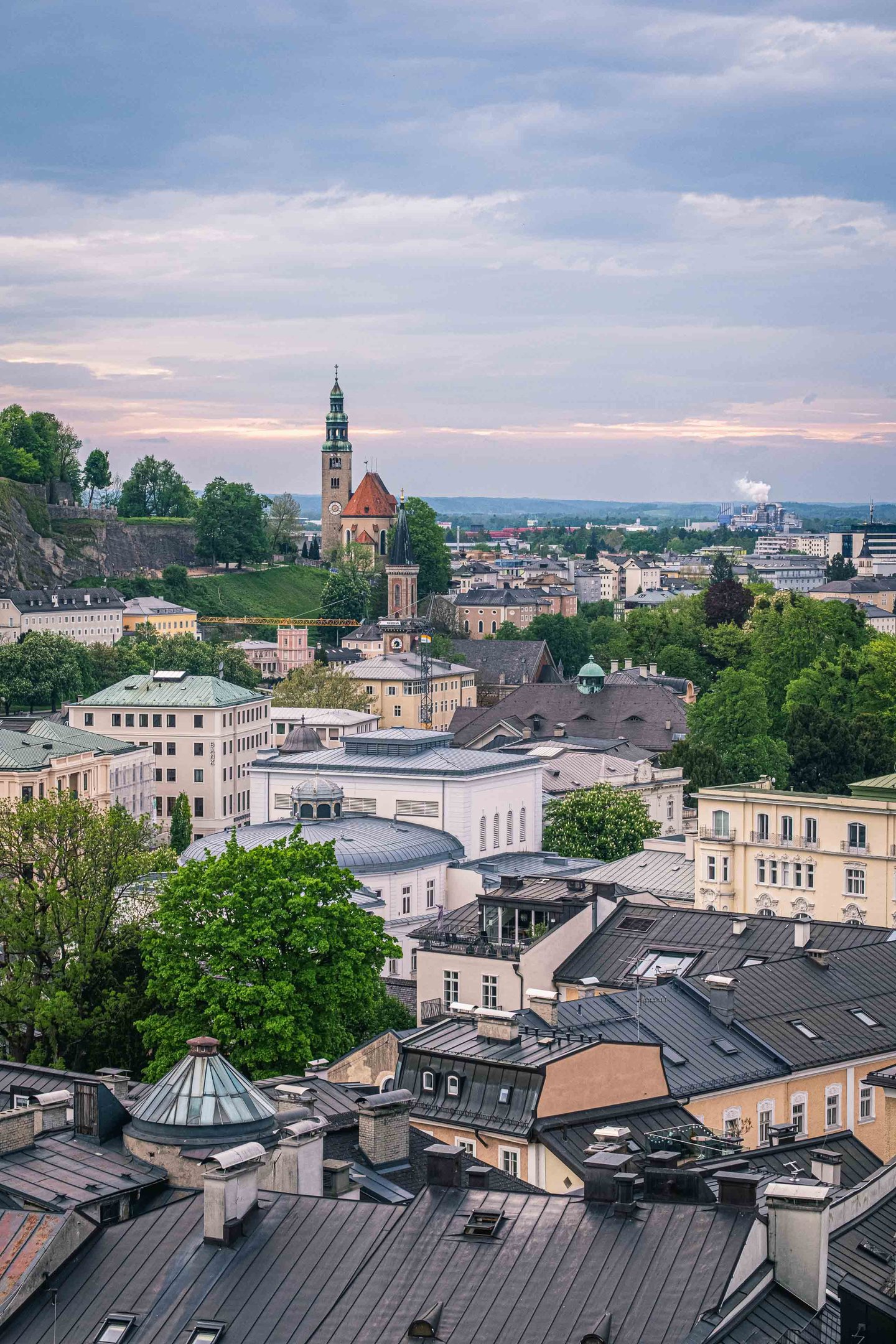 Muelln Church and Festspielhaus roofs seen from Kapuzinerberg at dusk in Salzburg.