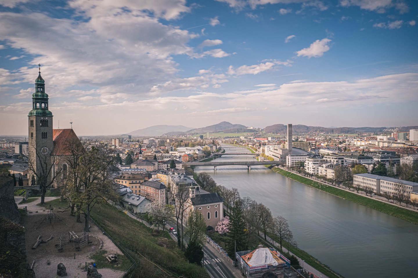 Muellner Kirche dome and tower above the Salzach river and north city views in Salzburg.