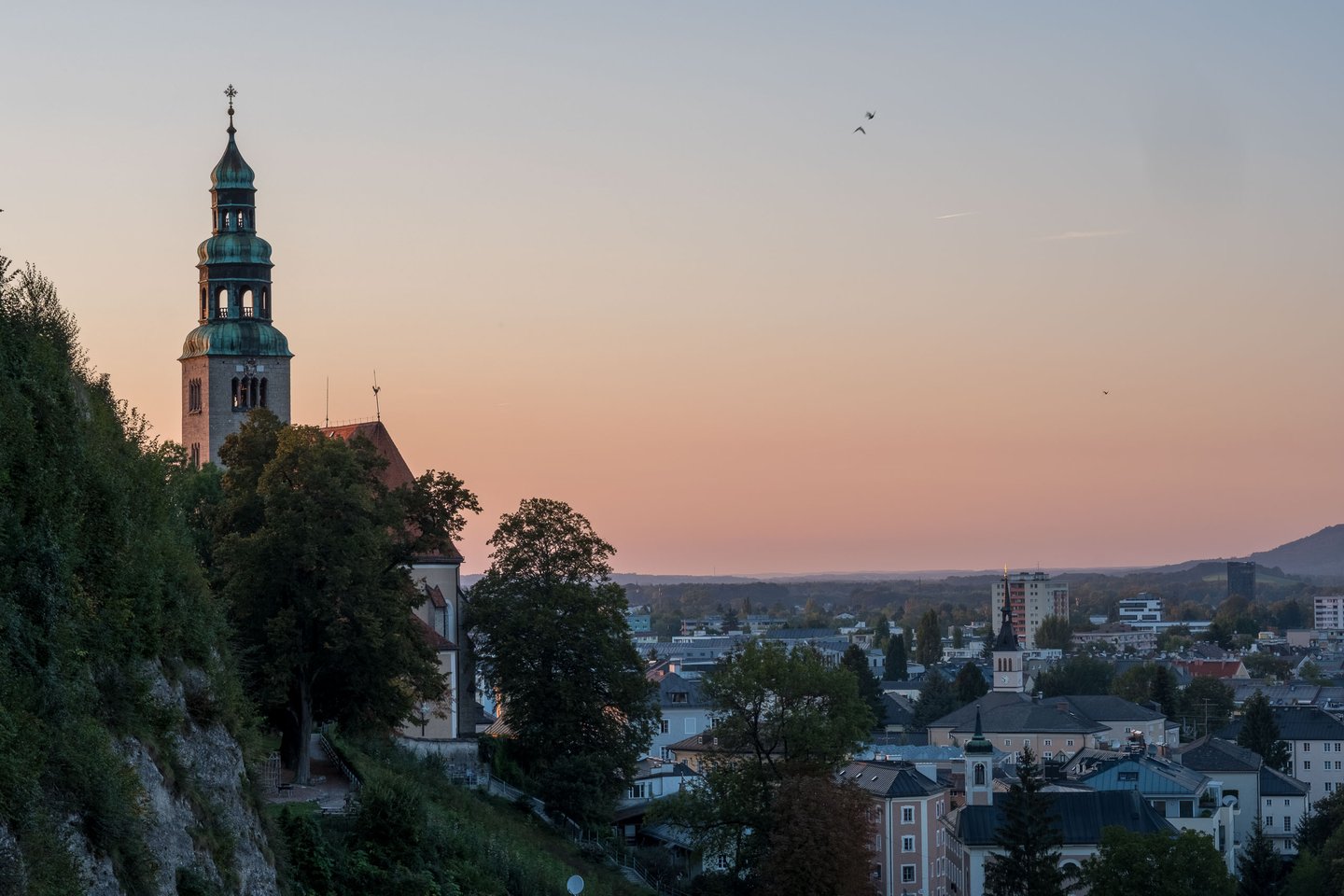 Mülln Church with green onion dome tower at sunset seen from Mönchsberg in Salzburg