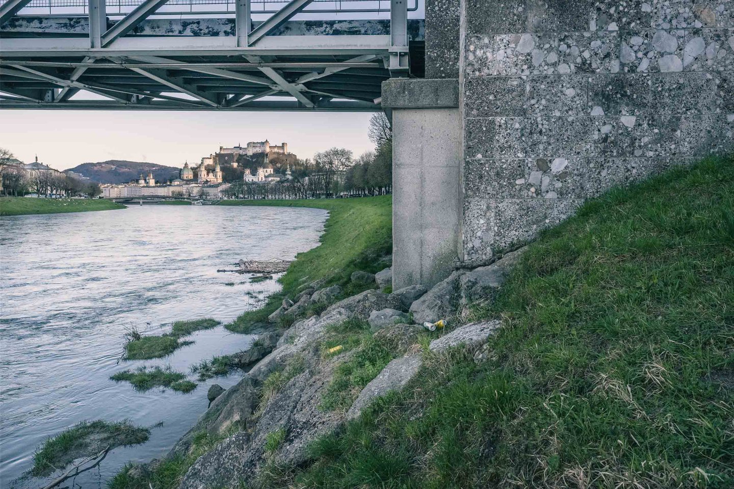 View from under Muellnersteg bridge along Salzach river toward Hohensalzburg Fortress in Salzburg.