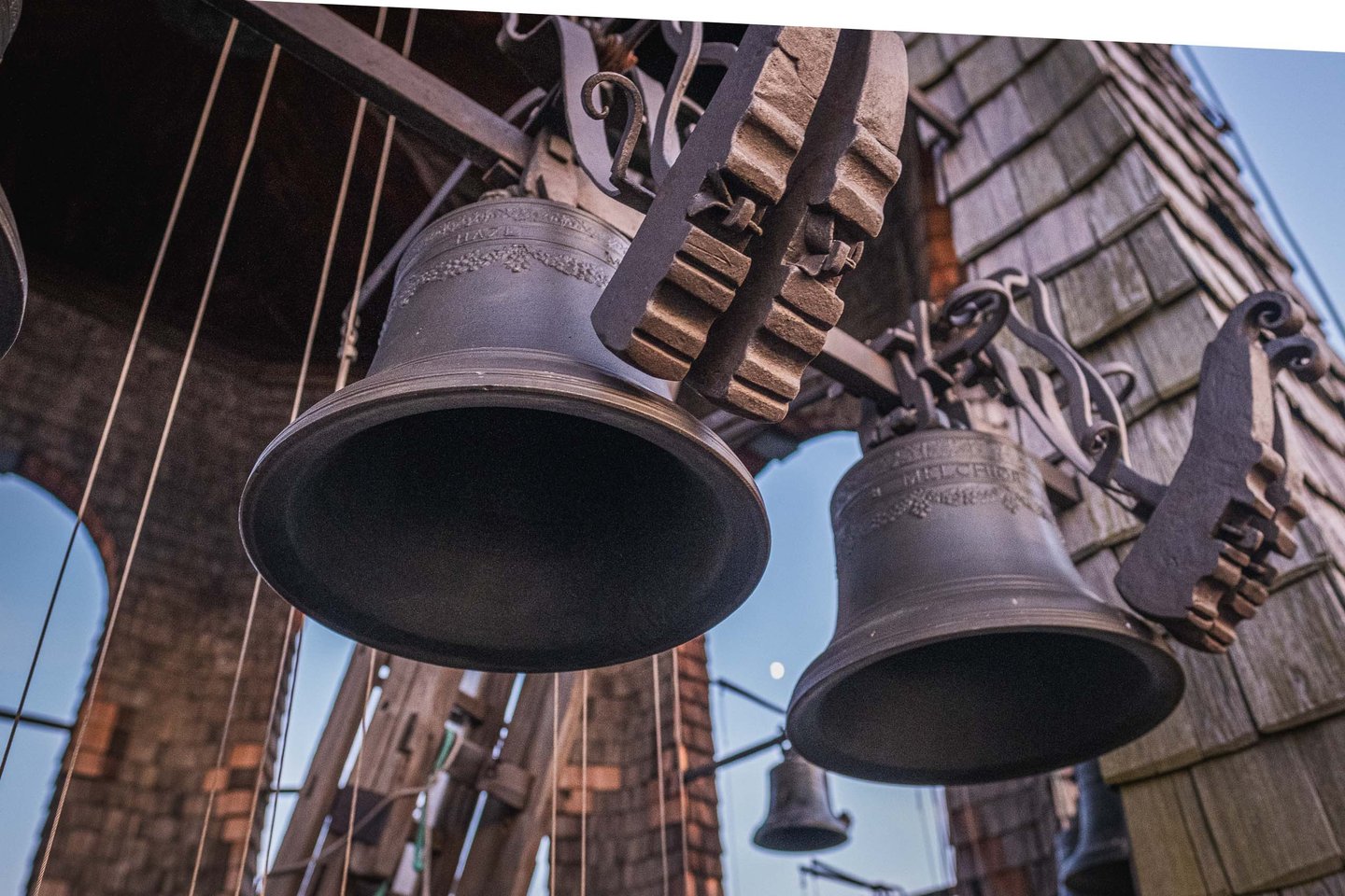 Bronze bells of the Glockenspiel carillon hanging from wooden frame inside tower in Salzburg