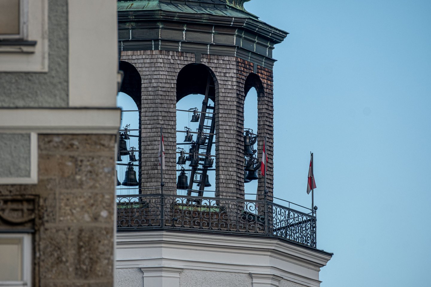 Glockenspiel tower of Neue Residenz showing bells and flags with fortress behind in Salzburg