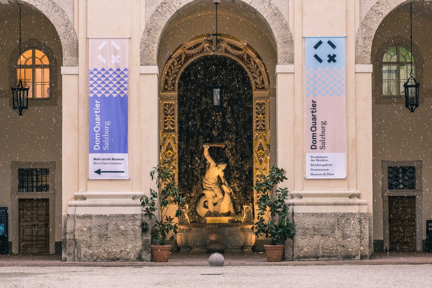 Baroque sculpted niche with fountain figure inside the Residenz DomQuartier arcade in Salzburg old town.
