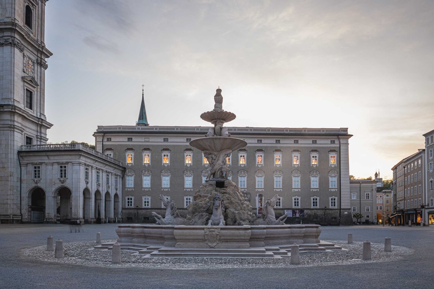 Residenzbrunnen baroque fountain with horse figures on empty Residenzplatz at dusk in Salzburg