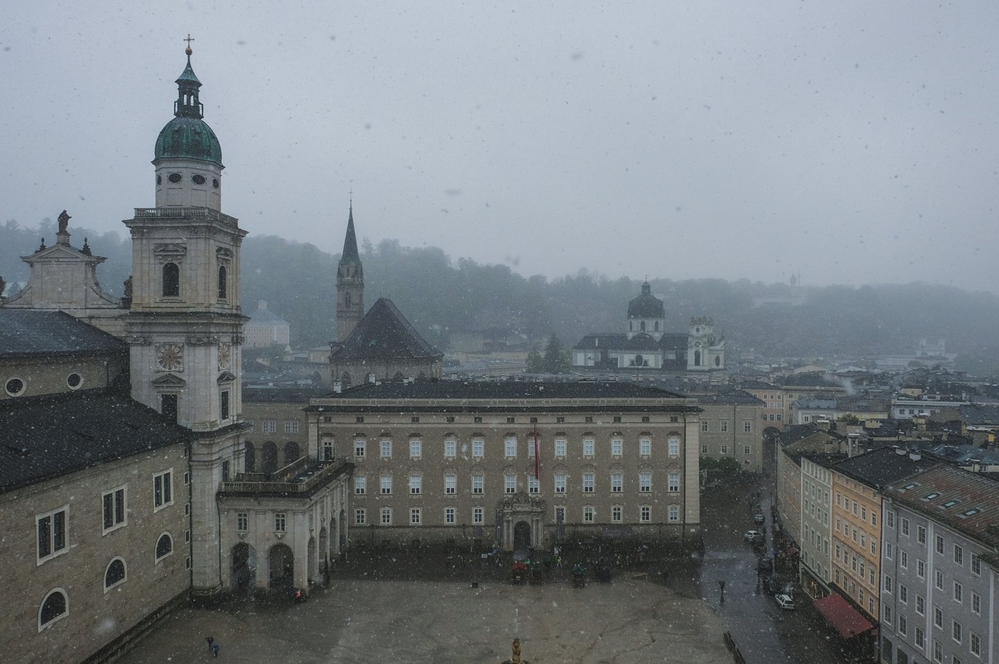 Residenzplatz and the cathedral towers seen from Hohensalzburg Fortress during light snowfall in Salzburg