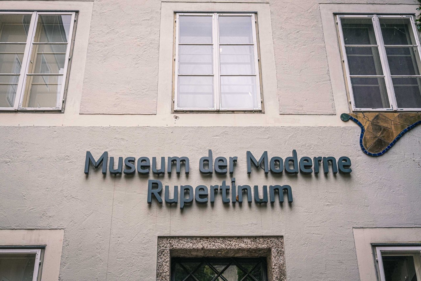 Close-up of the Museum der Moderne Rupertinum blue signage on the baroque facade in Salzburg old town.