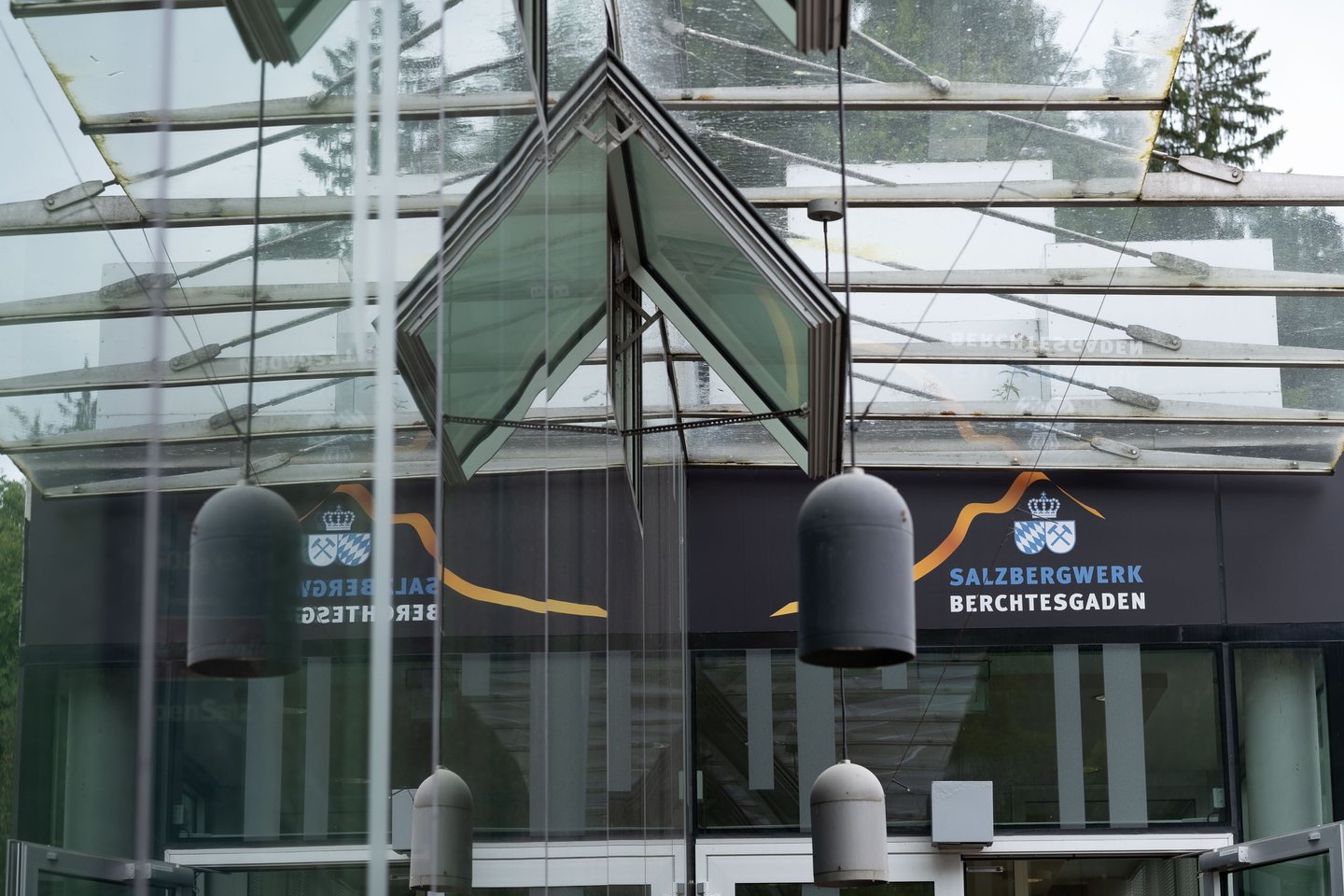 Glass entrance pavilion of the Salzbergwerk Berchtesgaden with crown logo signage in Bavaria