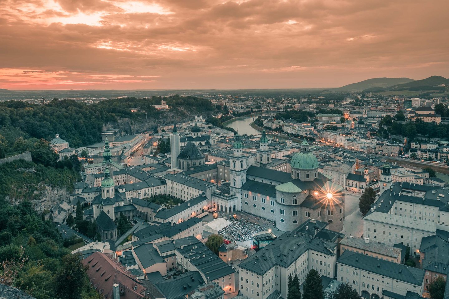 Salzburg Cathedral illuminated at sunset seen from Hohensalzburg Fortress above the old town.