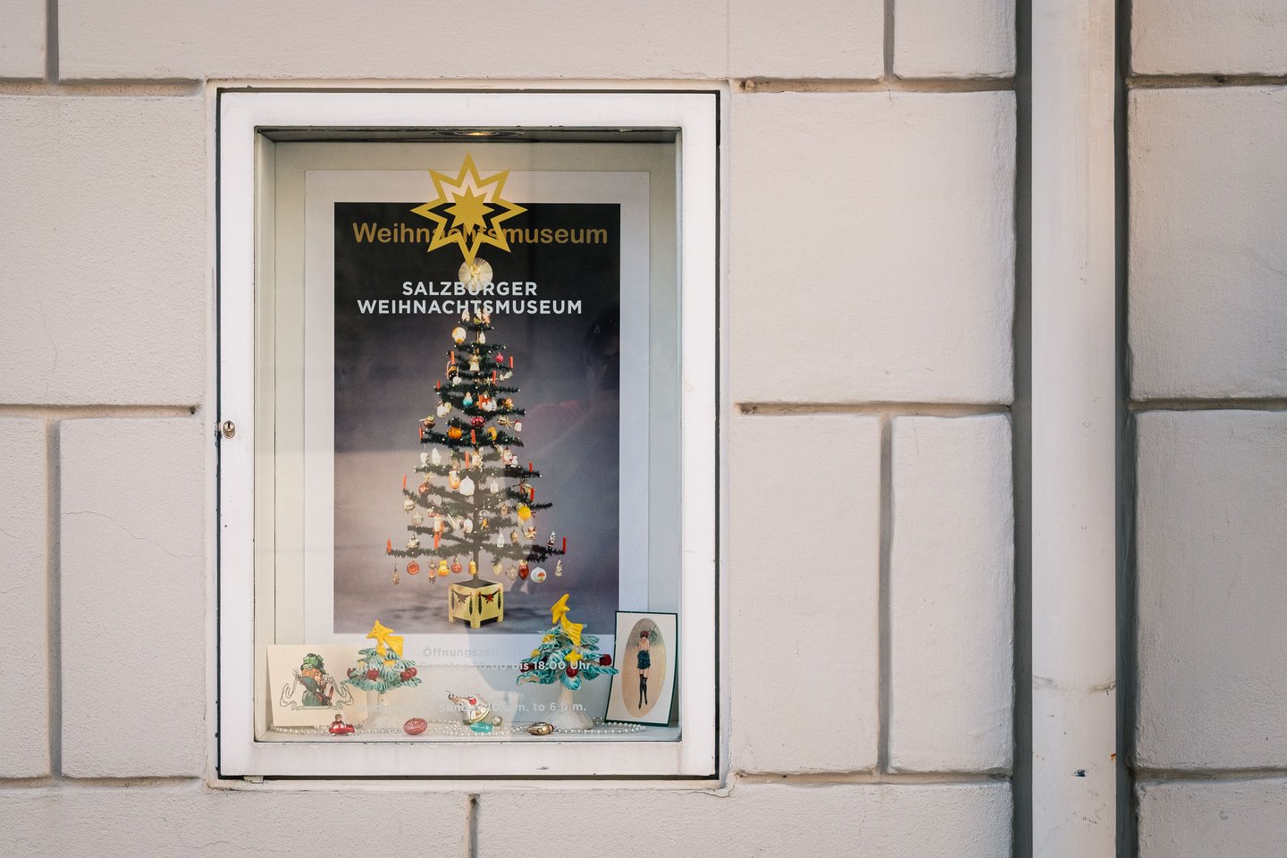 Salzburger Weihnachtsmuseum poster with lit Christmas tree displayed in shop window in Salzburg