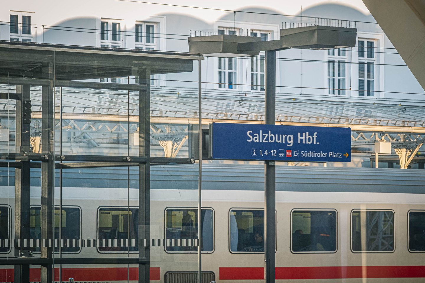 Salzburg Hauptbahnhof platform with blue station sign and InterCity train in Salzburg