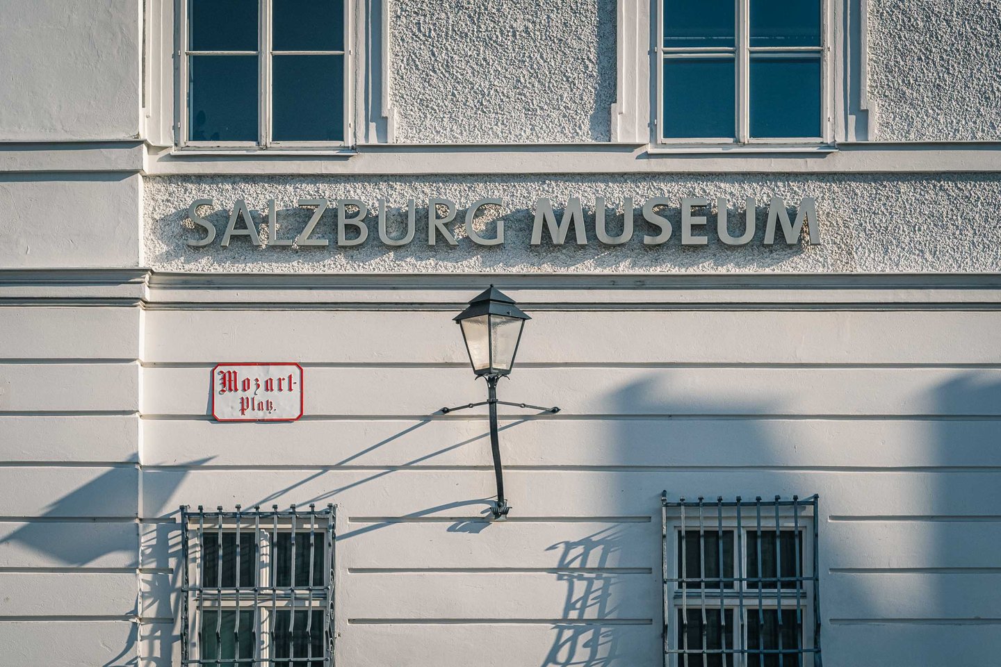 Salzburg Museum lettering and Mozartplatz sign on the Neue Residenz facade in Salzburg.