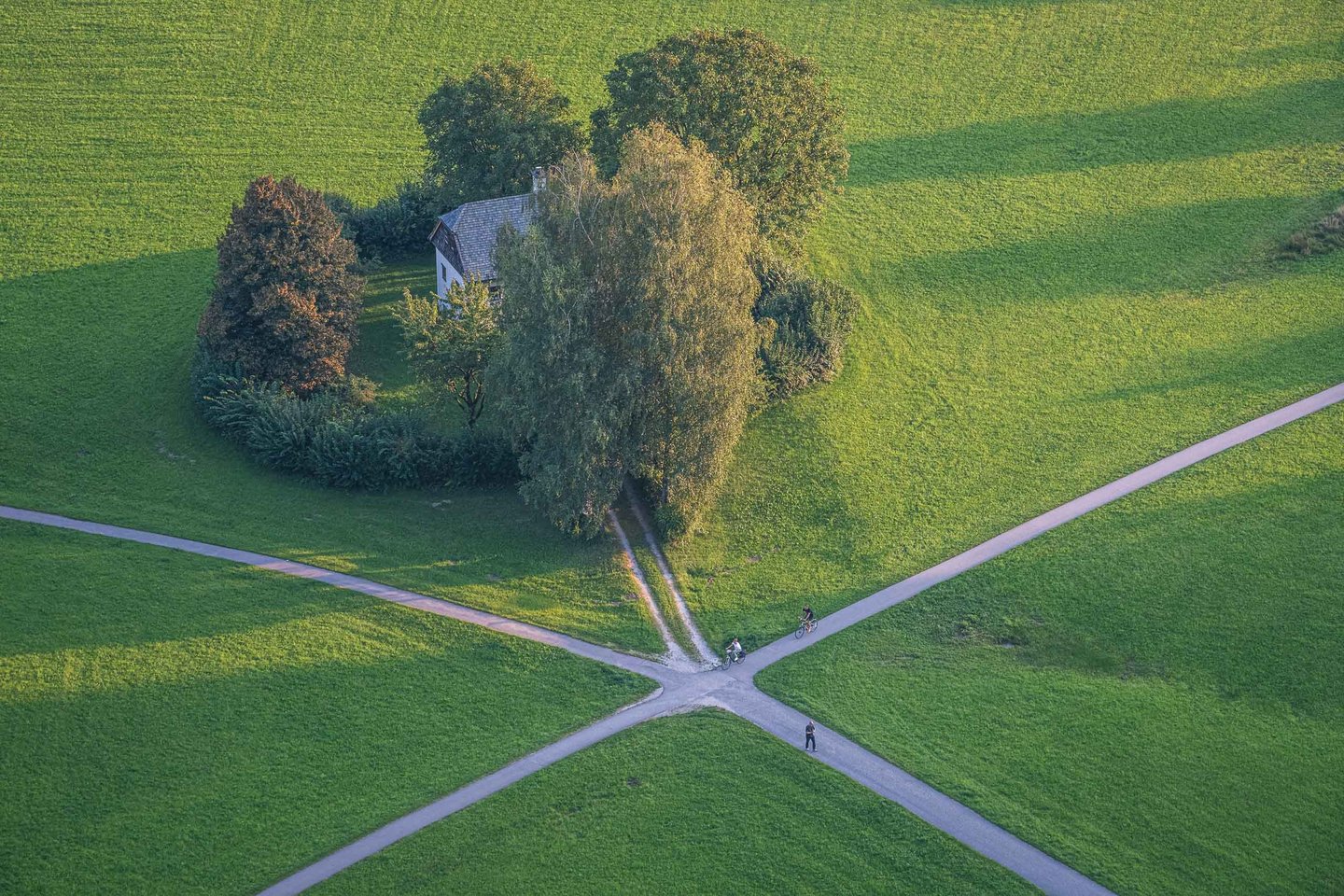 Aerial view from Hohensalzburg Fortress over the Freisaal meadows in Salzburg Nonntal with the small historic Henkershaus at a path crossroads