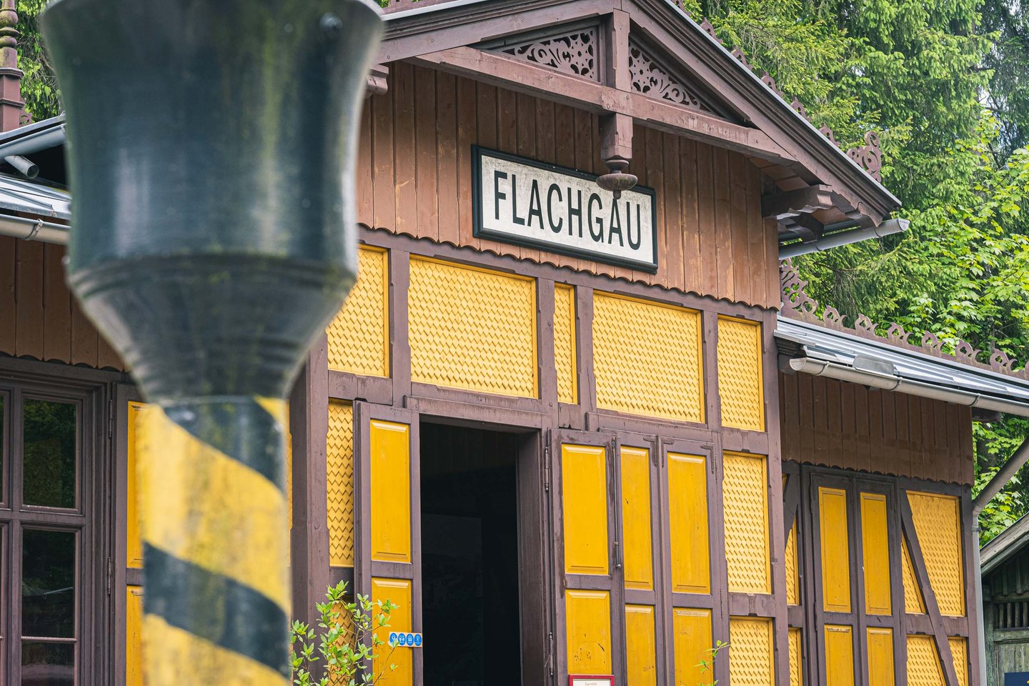 Yellow half-timbered Flachgau station building at Salzburger Freilichtmuseum in Grossgmain