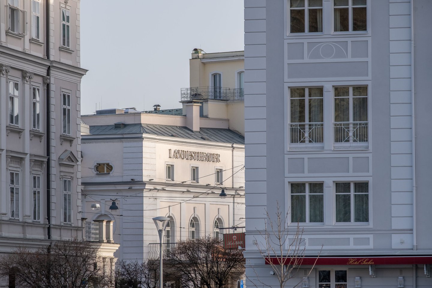 Salzburger Landestheater white facade framed between buildings in the morning light in Salzburg.