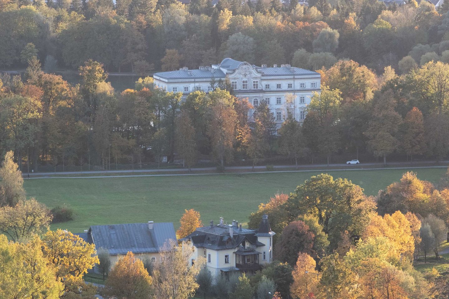Schloss Leopoldskron baroque palace surrounded by autumn trees seen from Monchsberg in Salzburg.