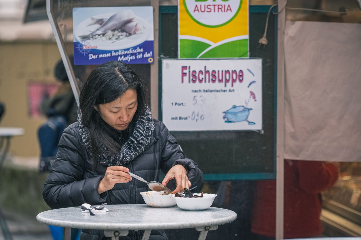 Visitor enjoying fish soup at a stall at the Schranne Salzburg weekly farmers market on Mirabellplatz