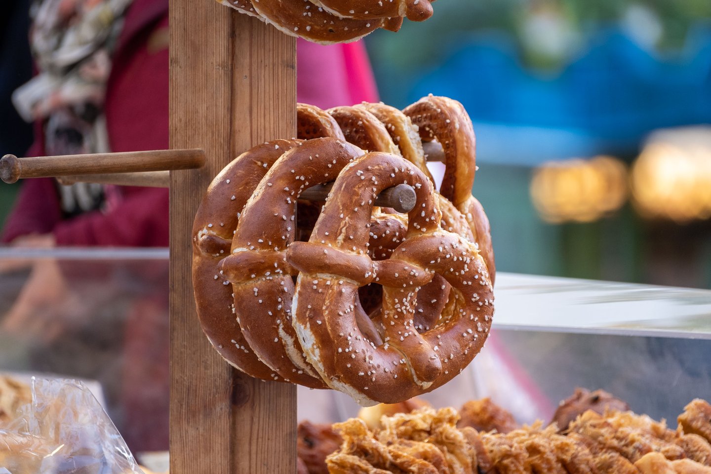 Large salted pretzels hang from wooden pegs at a stall at the Schrannenmarkt farmers market in Salzburg
