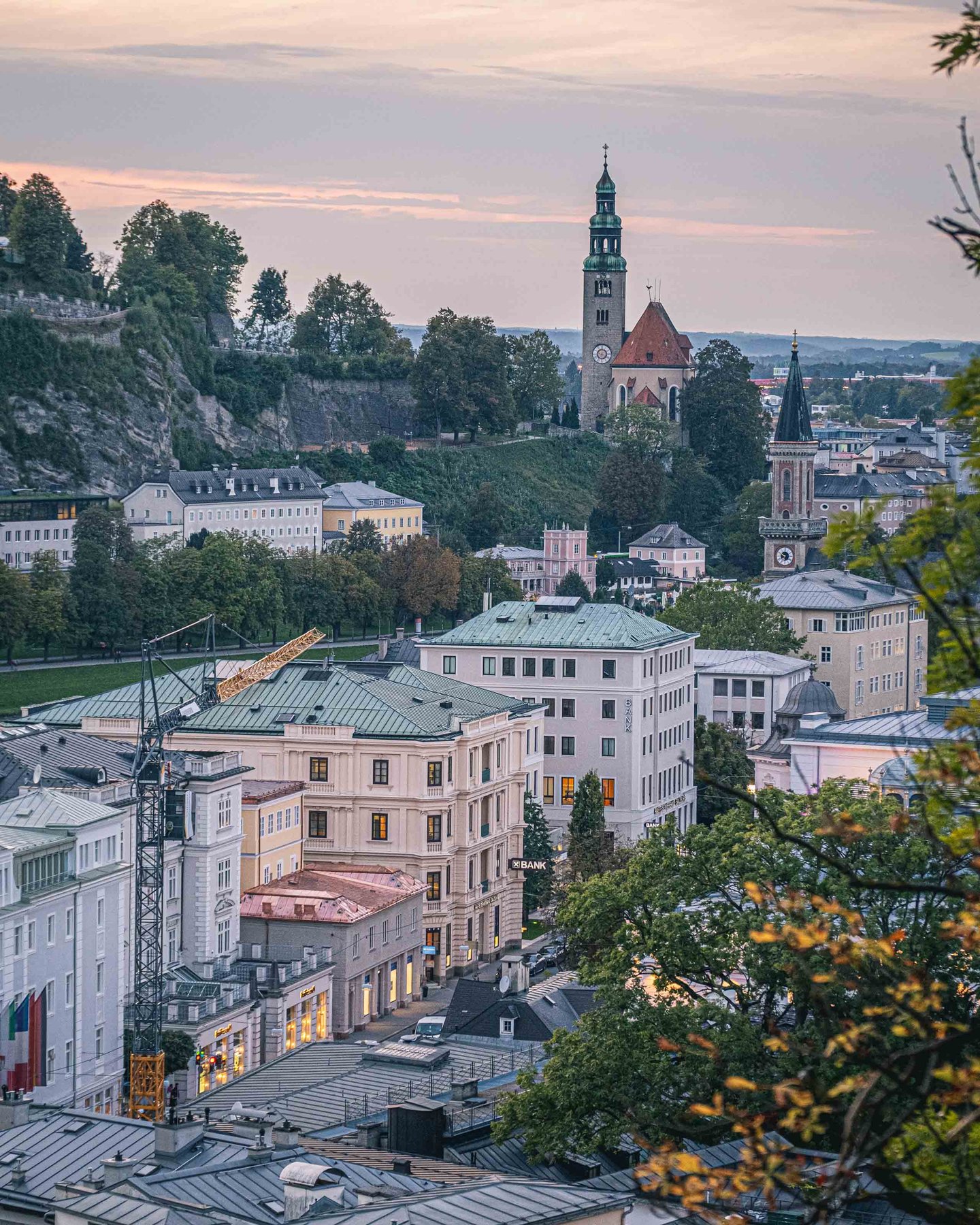Evening view from Kapuzinerberg over Altstadt rooftops with Schwarzstrasse area buildings across the Salzach in Salzburg