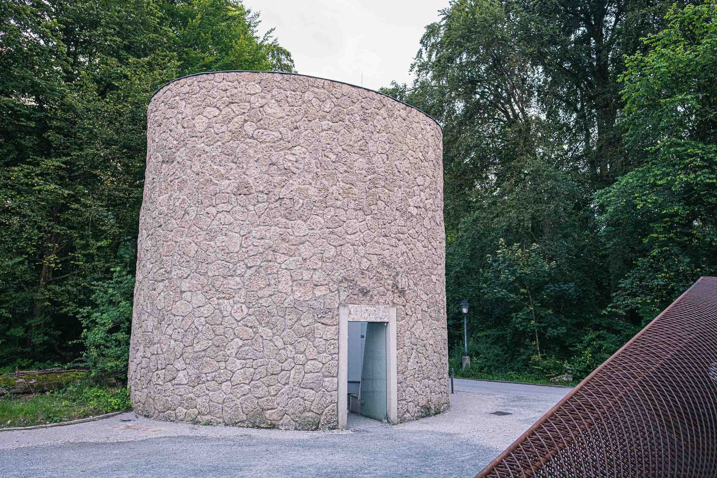 Elliptical conglomerate stone tower of the James Turrell Sky Space on the Monchsberg in Salzburg with its entrance door