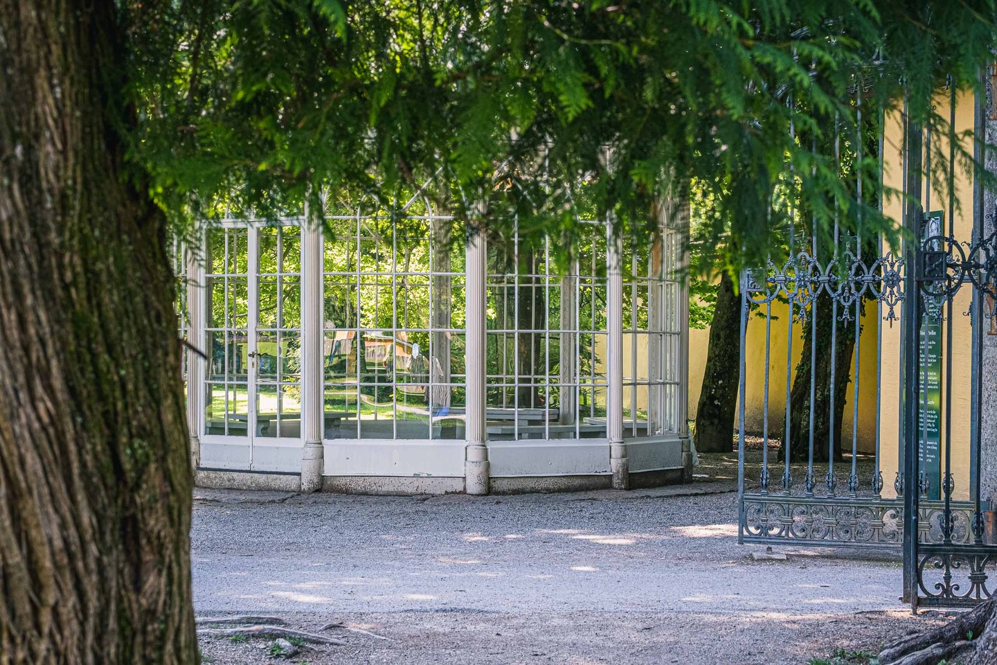 Sound of Music glass pavilion seen through iron gate in Hellbrunn Palace gardens near Salzburg.
