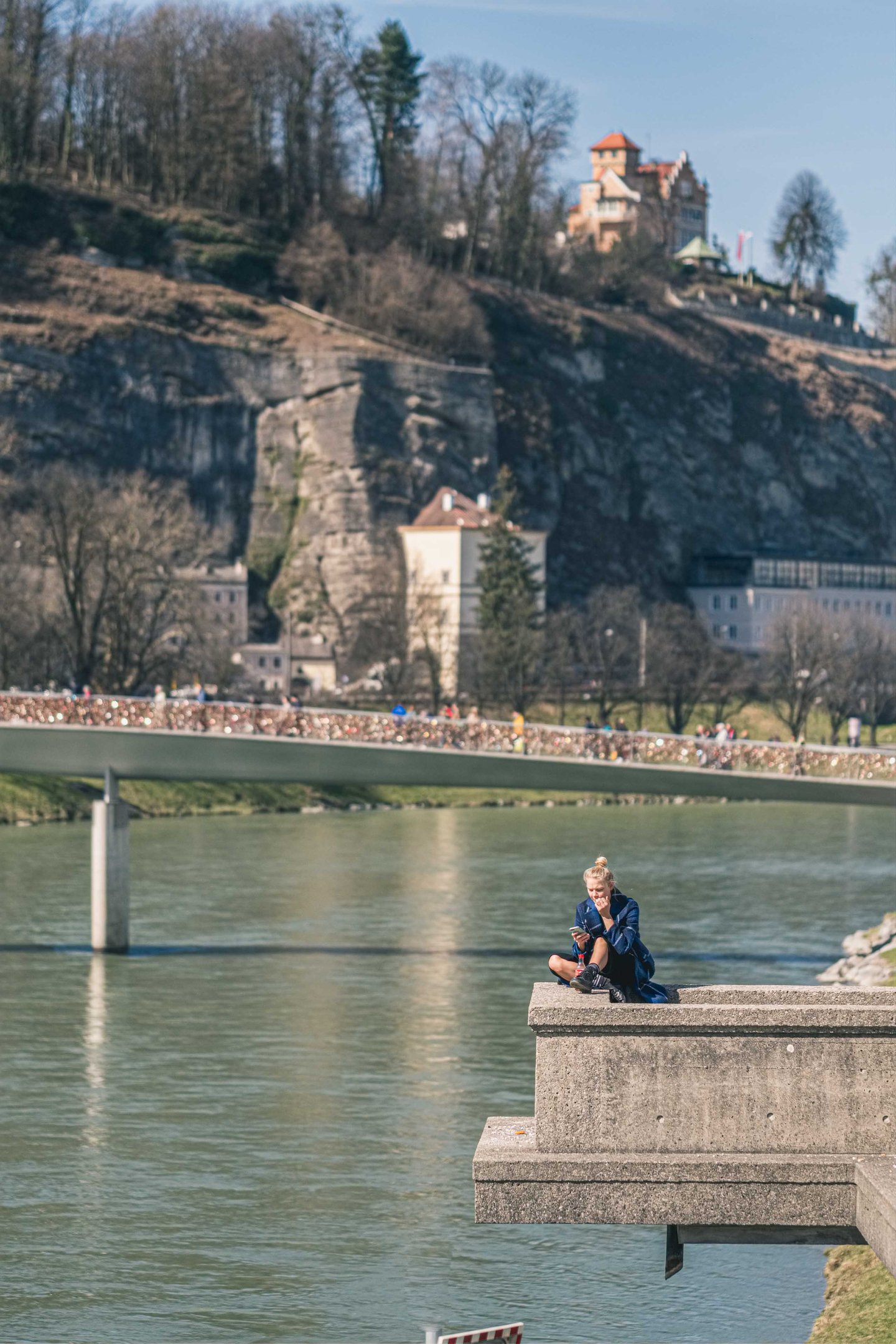 Salzach embankment in summer at the Spirit of Mozart location with the Staatsbruecke in the foreground and the Marko-Feingold-Steg behind