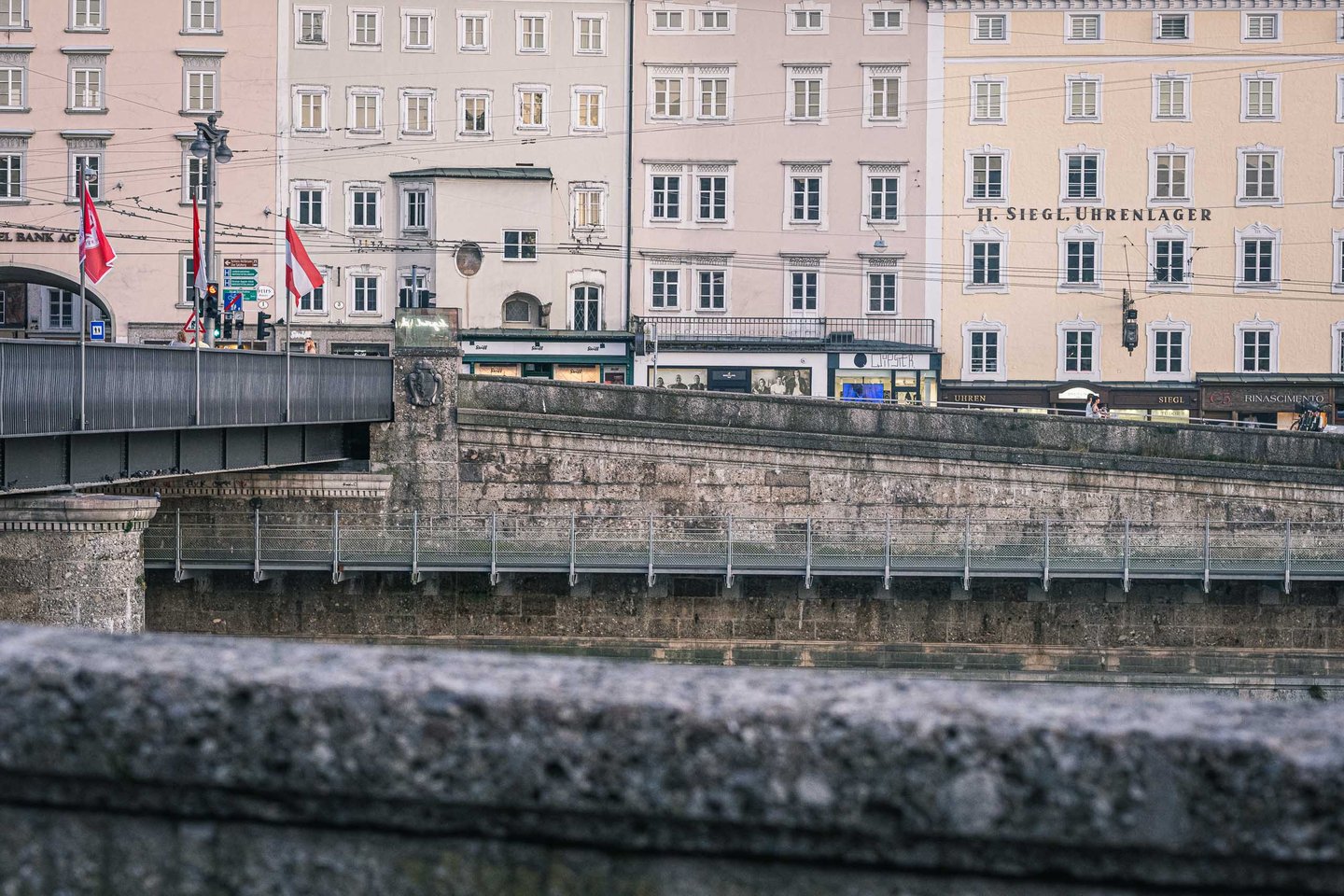 Staatsbruecke bridge parapet with old town facades along the Salzach river in Salzburg.