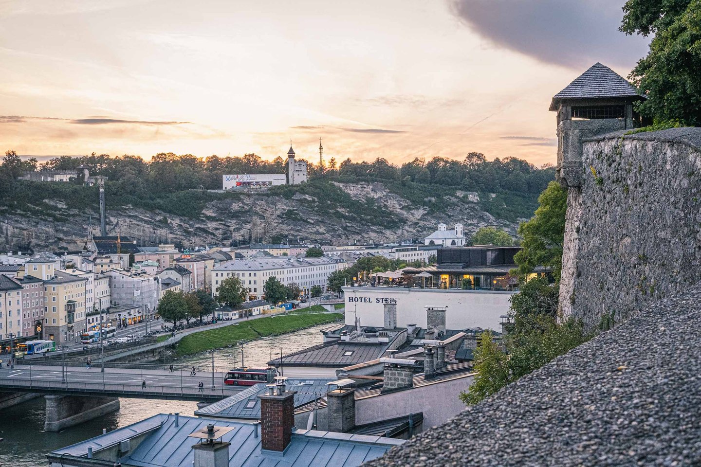 Sunset view toward Mulln and Monchsberg with Hotel Stein terrace and Salzach in foreground from Kapuzinerberg in Salzburg