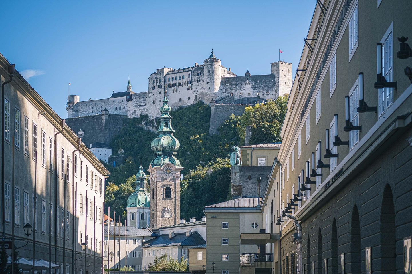 St Peter Abbey tower with green onion dome and Hohensalzburg fortress above in Salzburg old town
