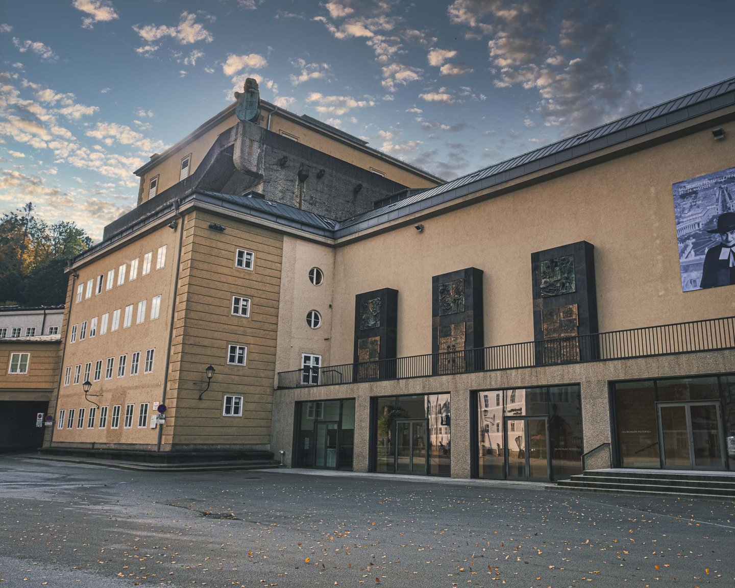 Festspielhaus exterior with bronze reliefs and contemporary banners seen from Toscaninihof in Salzburg old town.
