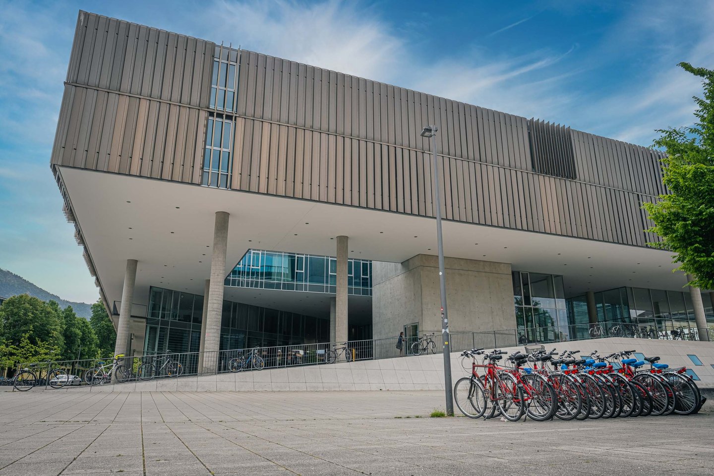 Modern cantilevered facade of Unipark Nonntal with bicycle racks in Salzburg