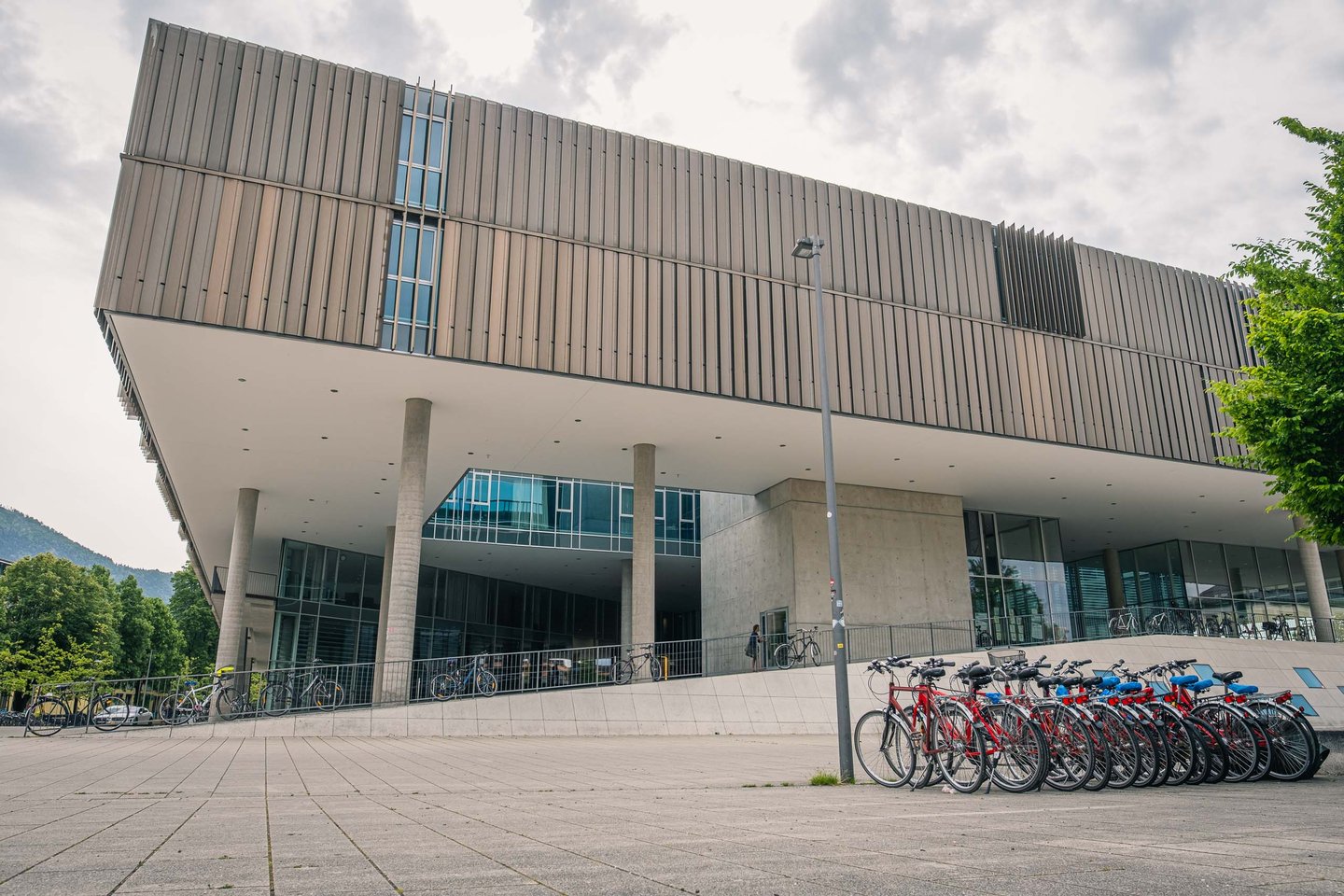 Modern cantilevered facade of Unipark Nonntal with bicycle racks in Salzburg