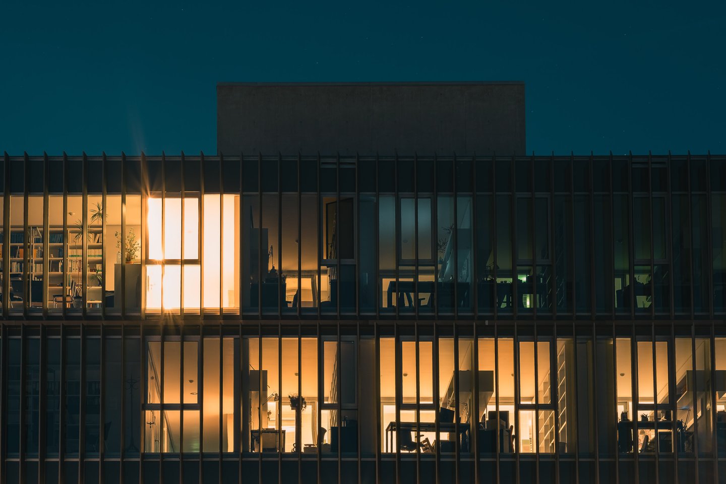 Unipark Nonntal University of Salzburg building exterior at night with concrete column undercroft