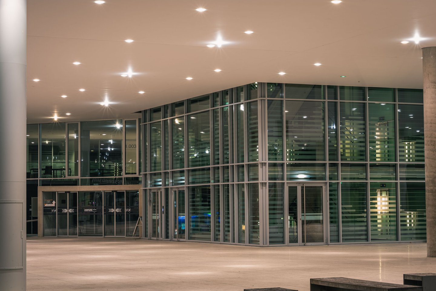 Unipark Nonntal building lit at night with glass facade in Salzburg