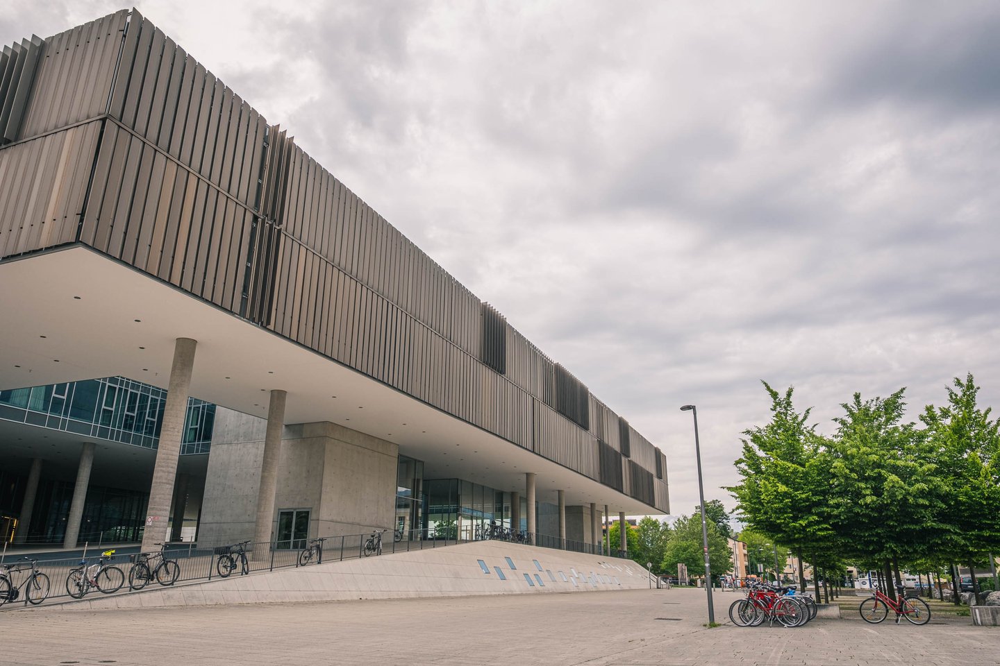 Side view of Unipark Nonntal modern facade with bicycles and plaza in Salzburg Nonntal