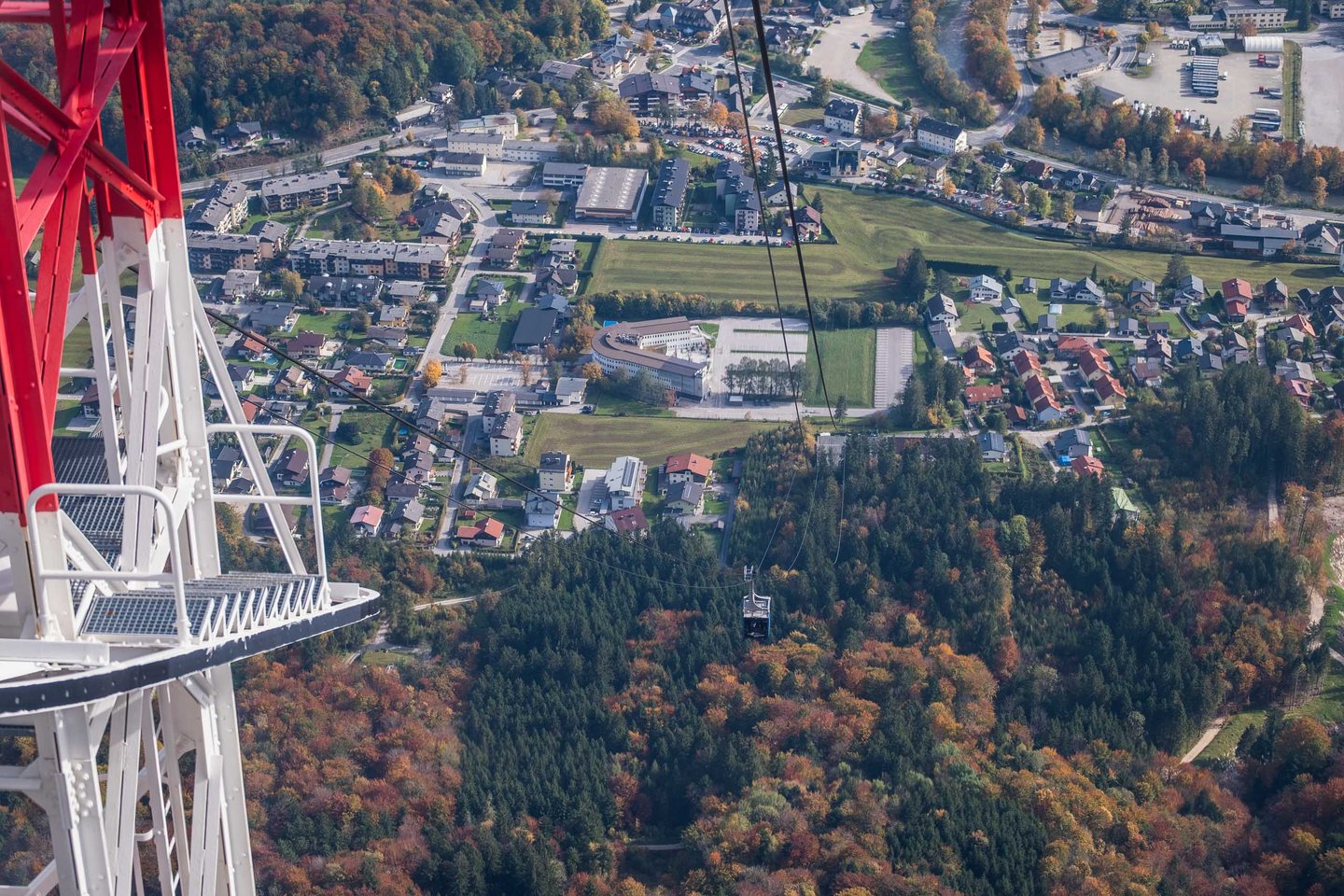 Cable car cabin descending toward Grodig valley seen from Untersbergbahn pylon in autumn