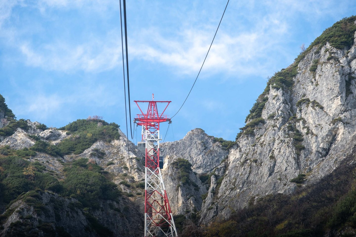 Red cable car support pylon between Untersberg limestone cliffs above Grodig near Salzburg