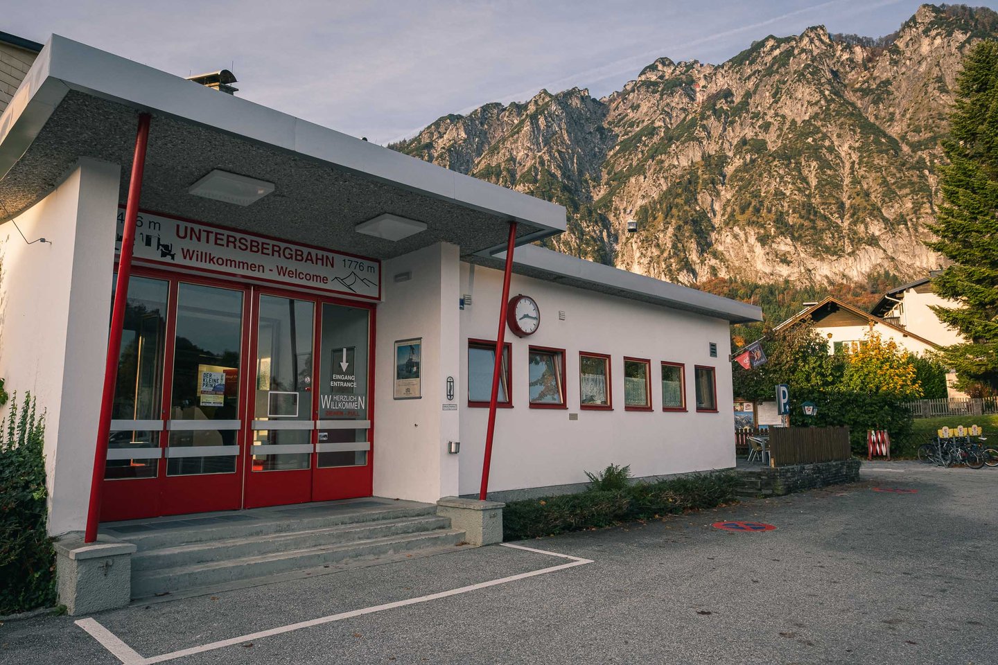 Entrance to the Untersbergbahn valley station with Willkommen signage and autumn mountainside behind.