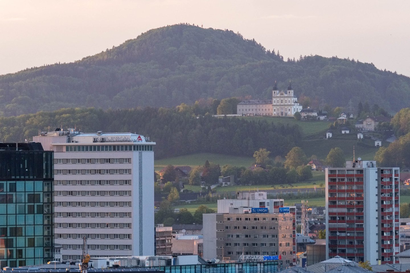 Maria Plain pilgrimage church on hill above modern apartment blocks in Salzburg.