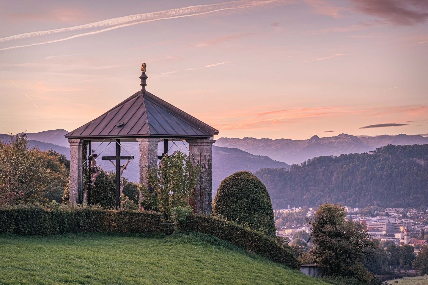 Kreuzweg crucifix pavilion on Maria Plain hill at sunset with Alps on the horizon near Salzburg.