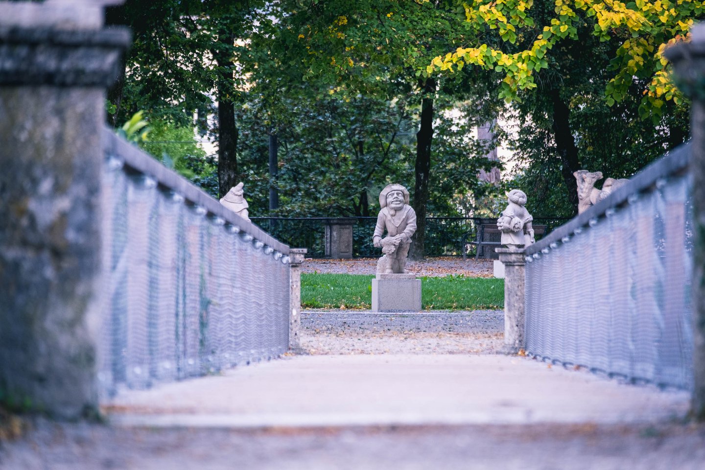 Stone dwarf statues along pathway in the Zwerglgarten dwarf garden in Mirabell Gardens Salzburg.