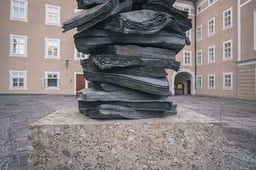 Stacked bronze books of Anselm Kiefer Die Sprache der Voegel sculpture in the Toscaninihof area in Salzburg.